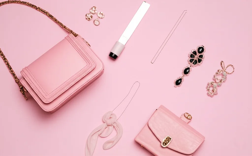 Fashion accessories arranged on a pink background