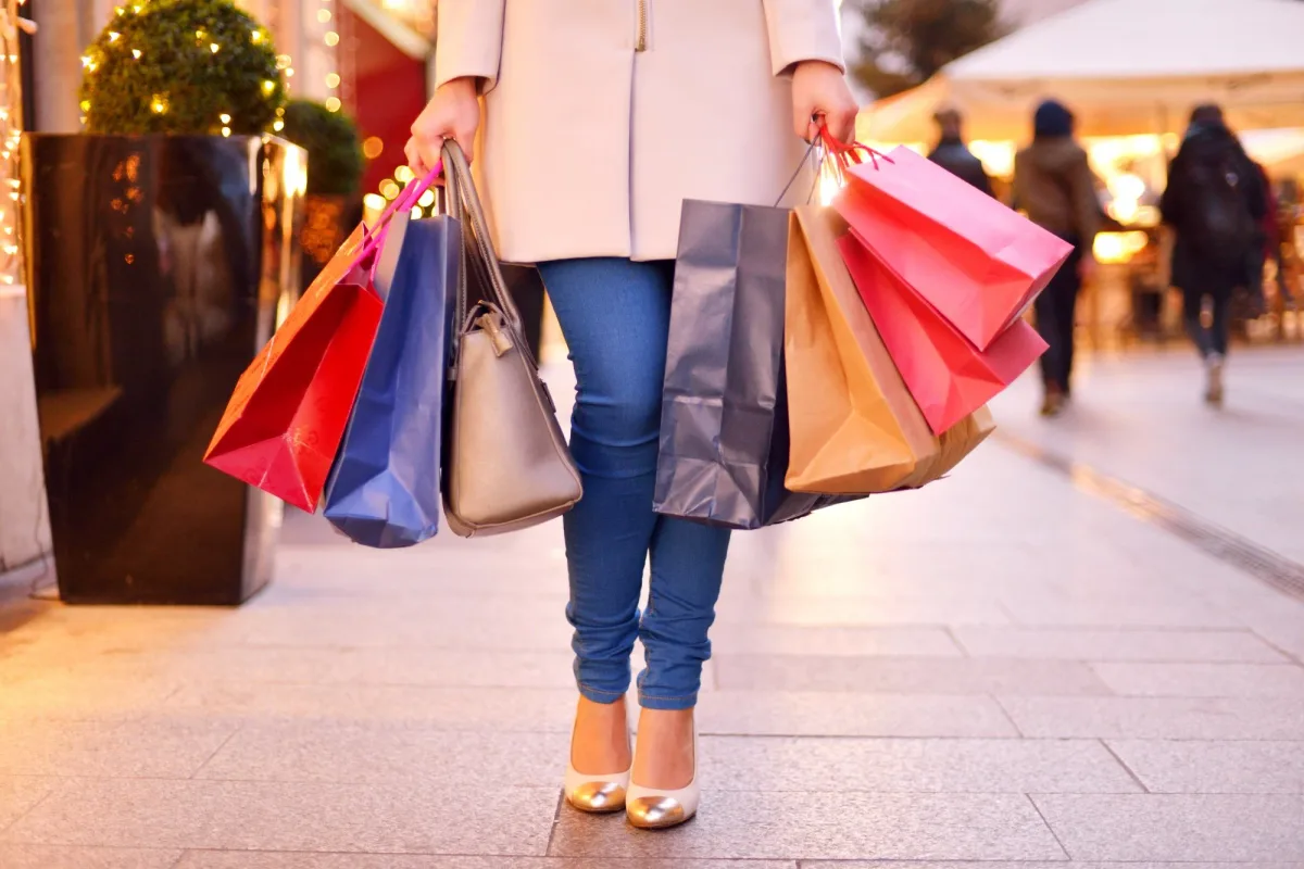 A shopper carrying bags after checking fashion products